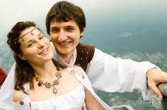 Wedding shot of bride and groom. Couple standing at mountain background. (Man and woman in suits of Middle Ages stile